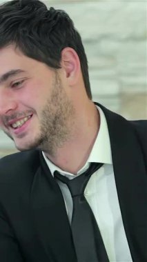 Zarif, modern bir ofiste, koyu saçlı iki kendine güvenen iş adamı ve traşlı bir kafa paylaşımı bir dizüstü bilgisayarı incelerken neşeli bir an. Parlak gülüşleri ve çekici ifadeleri yoldaşlık ve başarı saçıyor, ruhu somutlaştırıyor.