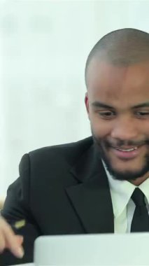 Aydınlık, modern bir ofiste, iki kendine güvenen iş adamı, biri koyu saçlı, diğeri ise tıraşlı kafa paylaşımlı, bir dizüstü bilgisayarı incelerken neşeli bir an. Işıltılı gülümsemeleri ve çekici ifadeleri takım çalışmasının ve işbirliğinin ruhunu somutlaştırıyor.