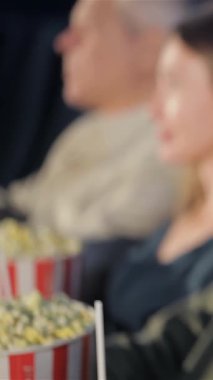 Işıl ışıl siyah bir kadın, nişanlı bir seyirci tarafından çevrelenmiş, rahat, loş bir sinemada kameraya neşeyle ışık saçıyor. İki erkek ve bir kadın sinemada aynı deneyimi paylaşırken atmosfer heyecanla uğulduyor. Patlamış mısır kovaları...