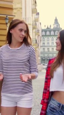 İki şık genç kadın, keyifli buluntularla dolu renkli alışveriş torbalarını tutarak gülerek ve hikayelerini paylaşarak pitoresk bir şehir caddesinde yürüyor. Canlı kıyafetleri ve ışıldayan gülümsemeleri kaygısız yaz günlerinin özünü yayıyor.