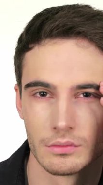 Kendine güvenen, çarpıcı özelliklere sahip genç bir adam aynanın karşısına geçip, yontulmuş çene çizgisini ve el değmemiş beyaz bir zemin karşısında büyüleyici gözlerini sergiliyor. Düşünceli bir ifadeyle, yüzündeki köpüğü nazikçe siler ve saçlarını siler.