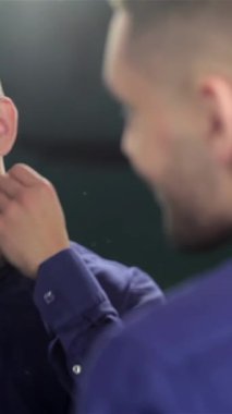 Moda bir berber dükkanında şık bir adam bakımlı sakalını okşar ve aynadaki yansımasına ışıldar. Bu büyüleyici sahne modern erkeksiliği somutlaştırıyor, tımar sanatını ve kişisel bakım ritüelini vurguluyor.