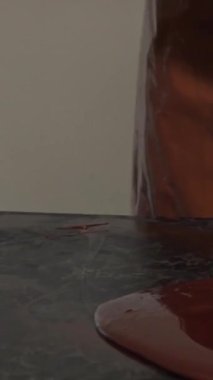 Canlı bir mutfakta, şık bir önlük ve eldiven giymiş kendini adamış bir çikolata üreticisi titizlikle pürüzsüz, parlak bir tezgahın üzerindeki erimiş çikolatayı lüks bir şekerlemeye dönüştürüyor. Bu dinamik sahne karmaşıklığı gösteriyor