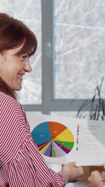 İki hayat dolu iş kadını, bir olgun, çarpıcı kızıl saçlı ve neşeli gülümsemesi olan bir genç şık, modern bir ofiste renkli iş haritalarını hevesle tartışıyor. Işıl ışıl enerjileri ve işbirlikçi ruhları...