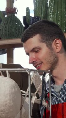 Canlı bitkiler ve sanatsal aletlerle dolu güneşli bir atölyede büyüleyici seramik bir heykel üzerinde tutkuyla çalışan genç bir çift görülüyor. Neşeli ifadeleri ve senkronize hareketleri çamura şekil verirken derin bir bağı yansıtır.