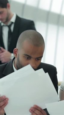 Kendine güvenen dört işadamı ve işkadınından oluşan odaklanmış bir grup, parlak, güneşli bir ofis masasında canlı bir tartışmaya dalmış, belgeleri analiz ediyor ve yenilikçi fikirler alışverişinde bulunuyor. Animasyon konuşmaları tutku yayıyor.