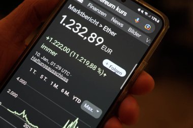 The hand of a man holding a mobile phone and checking the Ethereum - course gains - Google Chrome search, Radolfzell am Bodensee, January 10th, 2023