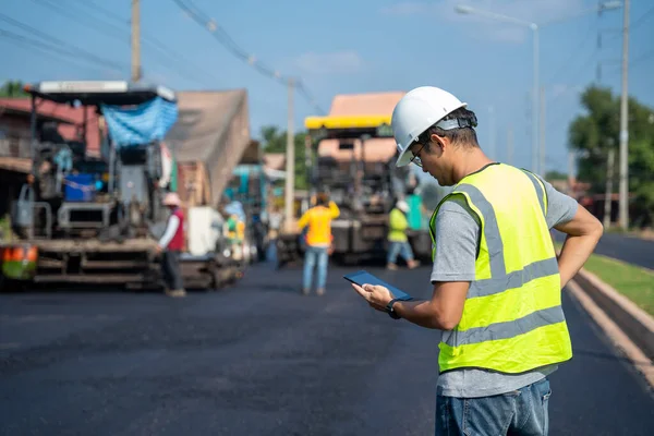 アスファルト舗装 道路ローラー ダンプトラックと労働者の建設道路の背景と道路建設現場で働くアジアの土木技術者 — ストック写真