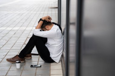 Asian man or People unemployed businessman stress sitting in urban public spaces. concept of business failure and unemployment problem. 