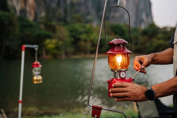 Close up hand of A man lanterns are lit lantern for light. Outdoor Camping Concept.