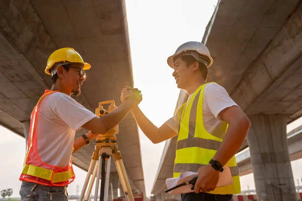 Asian teamwork success of civil engineer and surveyor engineers at road construction site, Surveyor equipment. Highway.