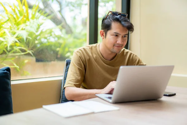 Asiático Freelance Hombre Asiático Guapo Mirando Pantalla Del Dispositivo Sonriendo —  Fotos de Stock
