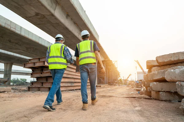 アジア二人の専門家は 道路建設現場 工業ビル建設現場で商業を検査します バックグラウンドクレーン 道路建設 土木技術者の超高層コンクリート — ストック写真