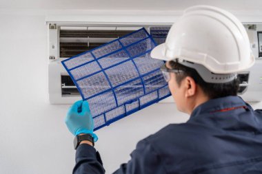 Hava teknisyeni temizlik için havalandırma filtresini kaldırıyor. Klima teknisyeni servis kavramı.