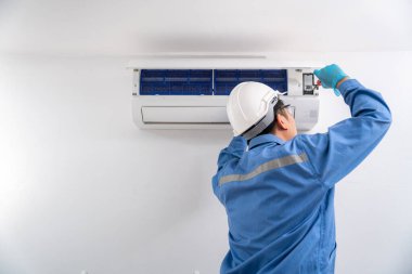 Havalandırma teknisyeni klimayı tamir ediyor ve yeni bir klima takıyor. Klima teknisyeni servis kavramı.