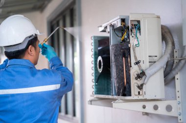 Klima teknisyeni klimayı temizlemek için yüksek basınçlı su jeti kullanıyor. Klima teknisyeni servis kavramı.
