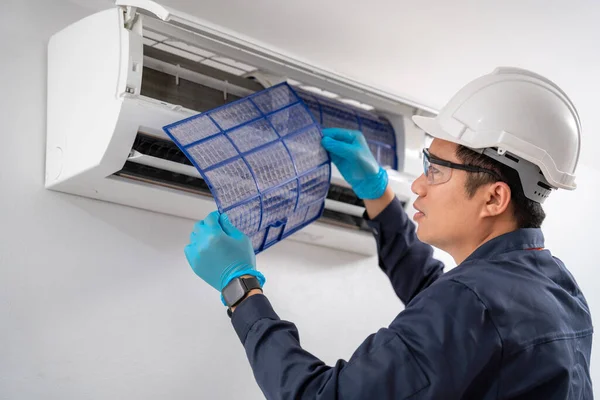 stock image Air technician service removing air filter of the air conditioner for cleaning. Service concept of an air conditioner technician.