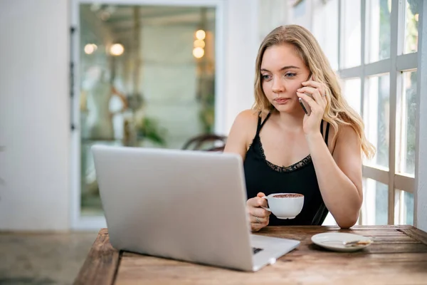 Uma Mulher Segurando Caneca Café Enquanto Olha Para Laptop Mesa — Fotografia de Stock