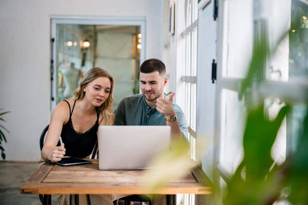 Молодая пара серфинга в Интернете с ноутбуком. Концепция пар, разделяющих одну идею вместе.