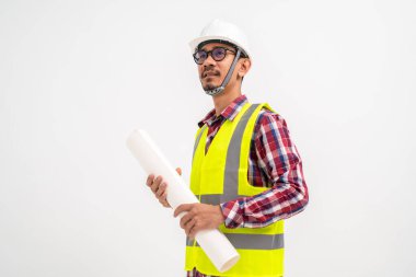Asyalı inşaat mühendisi, kafasında güvenlik kaskı olan beyaz bir plan tutuyor. İnşaat konsepti.