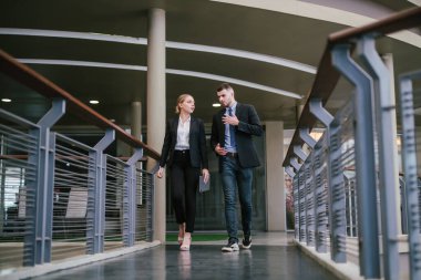 Ofisin dışında yürürken dijital tablet kullanan iki iş arkadaşı. İletişim konsepti.