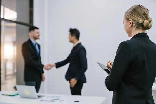 A woman writing on a tablet in the meeting room. Female secretary meeting recording concept.