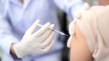Doktorun koluna grip aşısı yapılan hastanın omzuna aşı yapmaya yakın bir yerde. covid-19 aşı hastalığı insan klinik denemeleri için aşı hazırlığı.