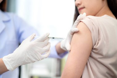 Koluna grip aşısı yapılan bir hastanın omzunda aşı yapan bir doktor.. 
