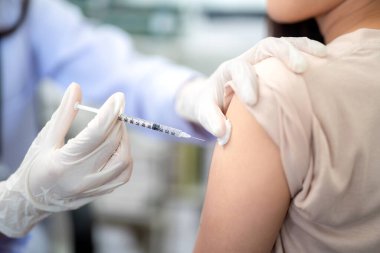 Doktorun hastasının omzunda aşı yapmasına yakın çekim. Coronavirus, grip aşısı Kol 'a enjeksiyon, covid-19 aşı aşısı insan klinik denemelerine hazırlanıyor..