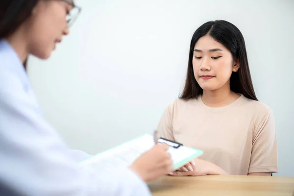 stock image A client or female patient is sitting and listening to the results of treatment from a female doctor at the clinic.