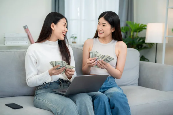 Две Молодые Азиатки Считают Деньги Ноутбуком Гостиной Концепция Продажи Продуктов — стоковое фото