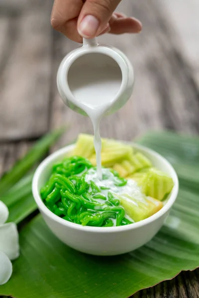 stock image Lod Chong being poured with fresh coconut milk on banana leaf on wooden background