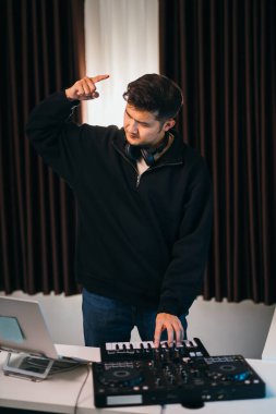 DJ blending smooth tunes on a mixer console at an intimate house event. clipart