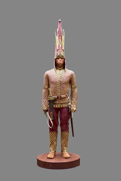 Reconstruction of an archaeological find - the Kazakh Golden Man on a grey background.Kazakh golden man.Archaeological find. Kazakh artifact. It represents the remains of a Saka warrior in golden clothing.