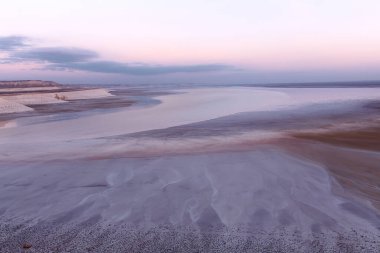 Salt Lake Tuzbair manzarası. Tuzbair Salt Gölü, Ustyurta platosunun doğusunda yer alır ve tuzlu göl veya tuzlu göl, çoğu gölden önemli ölçüde daha yüksek tuz ve çözünmüş diğer minerallere sahip denize kapalı bir su kütlesidir..