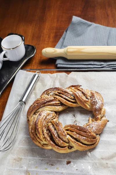 stock image Roscon de reyes Kringle Estonia. Typical Christmas sweet, braided sponge cake with cinnamon, butter, walnuts or almonds and icing sugar. Vertical photo and selective focus.