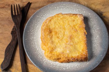 (Torrijas) Fried bread soaked in milk flavored with vanilla, cinnamon, lemon and egg on a wooden background.Typical Easter sweet. Concept of traditional festive cuisine.Selective focus.