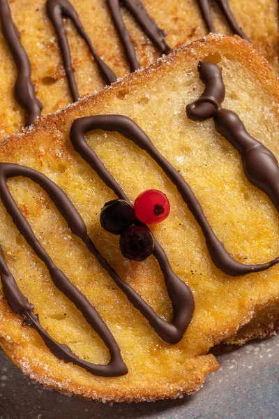 (Torrijas) Fried bread soaked in milk flavored with vanilla, cinnamon, lemon and egg with chocolate on a gray plate. Typical Easter sweet. Traditional festive cooking concept. Selective focus.
