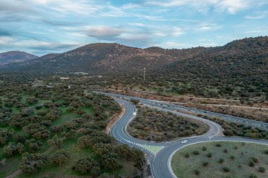 Aerial drone view of autumn landscape at sunset in northern Extremadura, Spain, with road, trees, plants and rocks. Concept of rural, healthy life, travel, transport, sport and adventure.