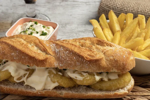 Tipik İspanyol kalamar sandviçi. Mayonez, sarımsak ve maydanozlu. Biraz kızarmış patates ve bir bardak soğuk bira. Tapas kavramı, eğlence ve gastronomi. Yatay fotoğraf ve seçici odak