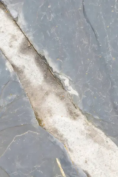 Çimento ve taş döşeme. Arkaplan, doku ve soyut tasarım imajı olarak ideal. Dikey fotoğraf ve seçici odak.