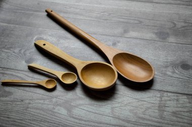 cucharas de madera de varios tamaos sobre una mesa gris rstica.