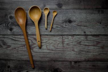 cucharas de madera de varios tamaos sobre una mesa gris rstica.
