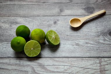 limones en una mesa gris rstica, uno de los limones se corta por la mitad.