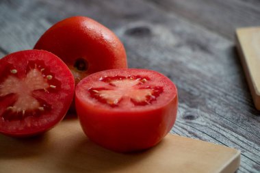 Bir la mitad en una tabla de cortar. Ben de ayık kalayım, ben de ayık kalayım. Cerca de la mesa saman otros tomates. luz nocturna