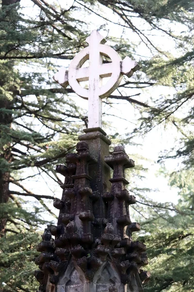 old stone cross on the background of a cemetery in  Dharshmala  India