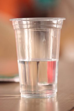 Masadaki plastik şişelerden bir bardak su ve içecek..