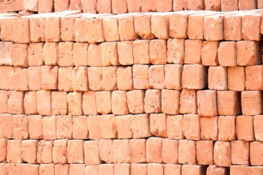 Arkaplan olarak kırmızı tuğla yığını, fotoğrafın yakın çekimi.