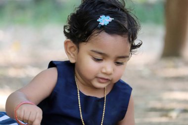 Saçında mavi bir çiçek olan genç bir kız.