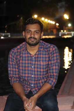 Yakışıklı genç adam, öylesine gülümsüyor, bir restoranın barında oturuyor.